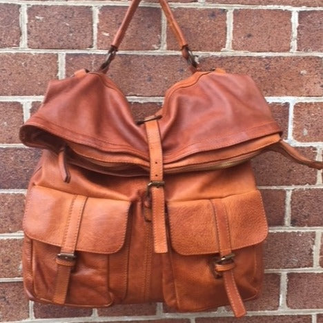The Liam backpack in natural hanging on a wall