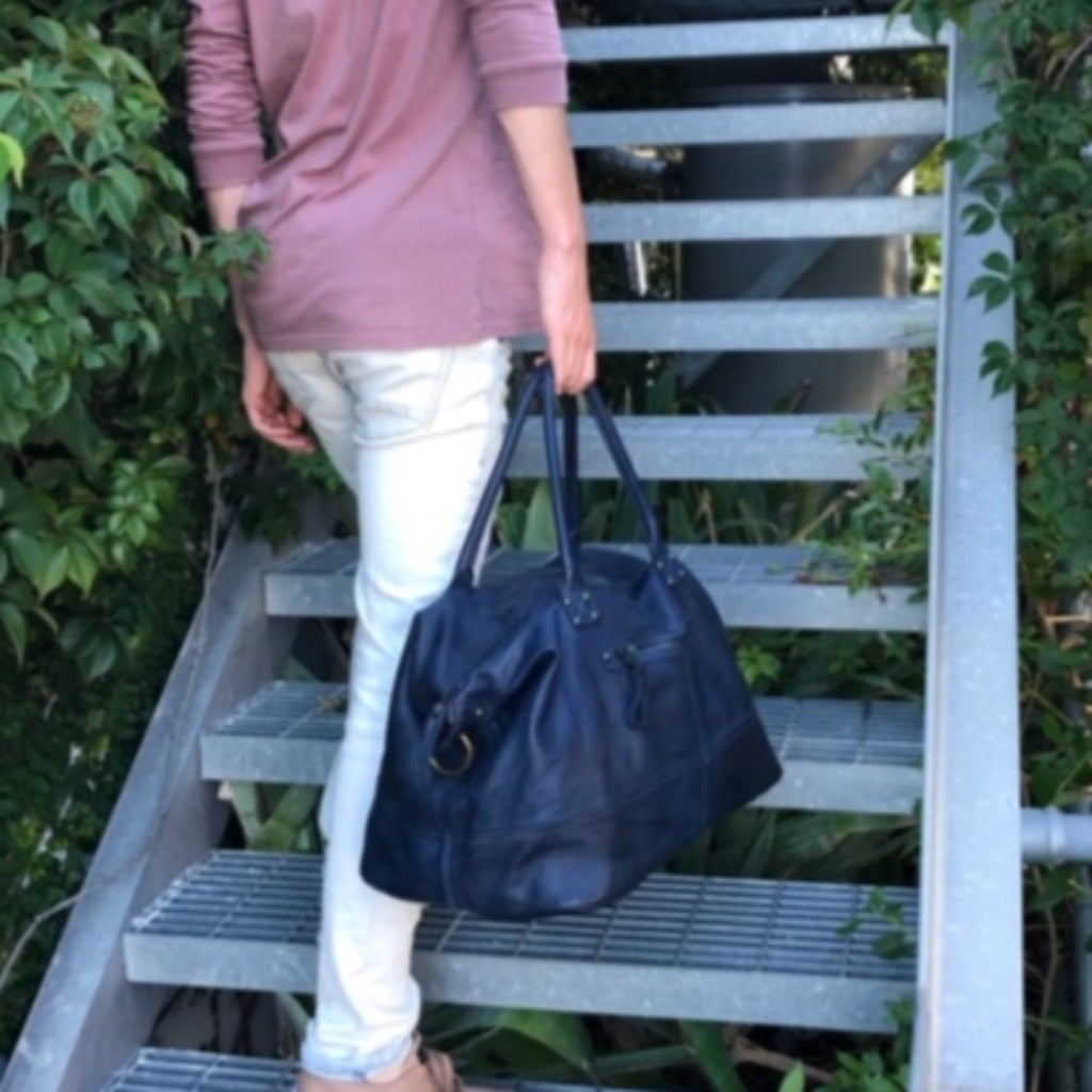 man with blue weekend bag walking up the stairs