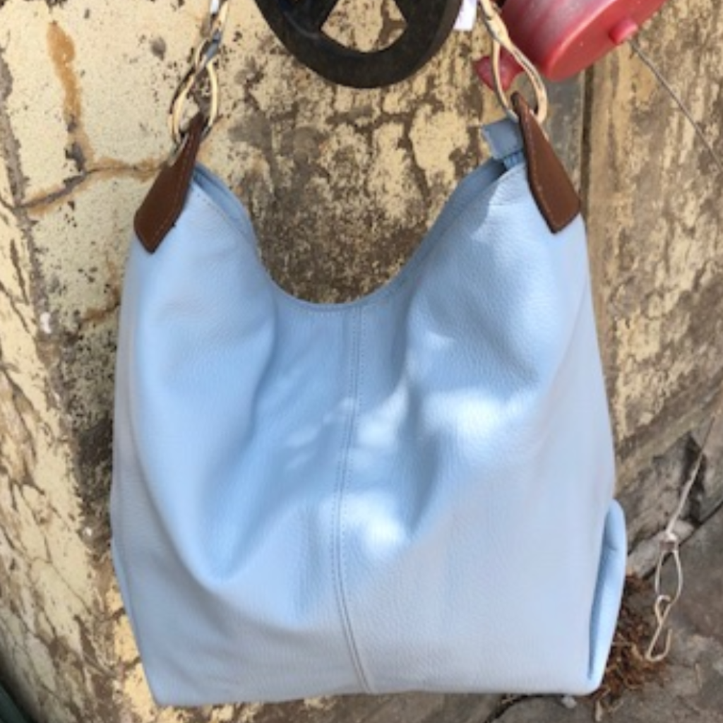 light blue Daisy bag hanging on a pipe