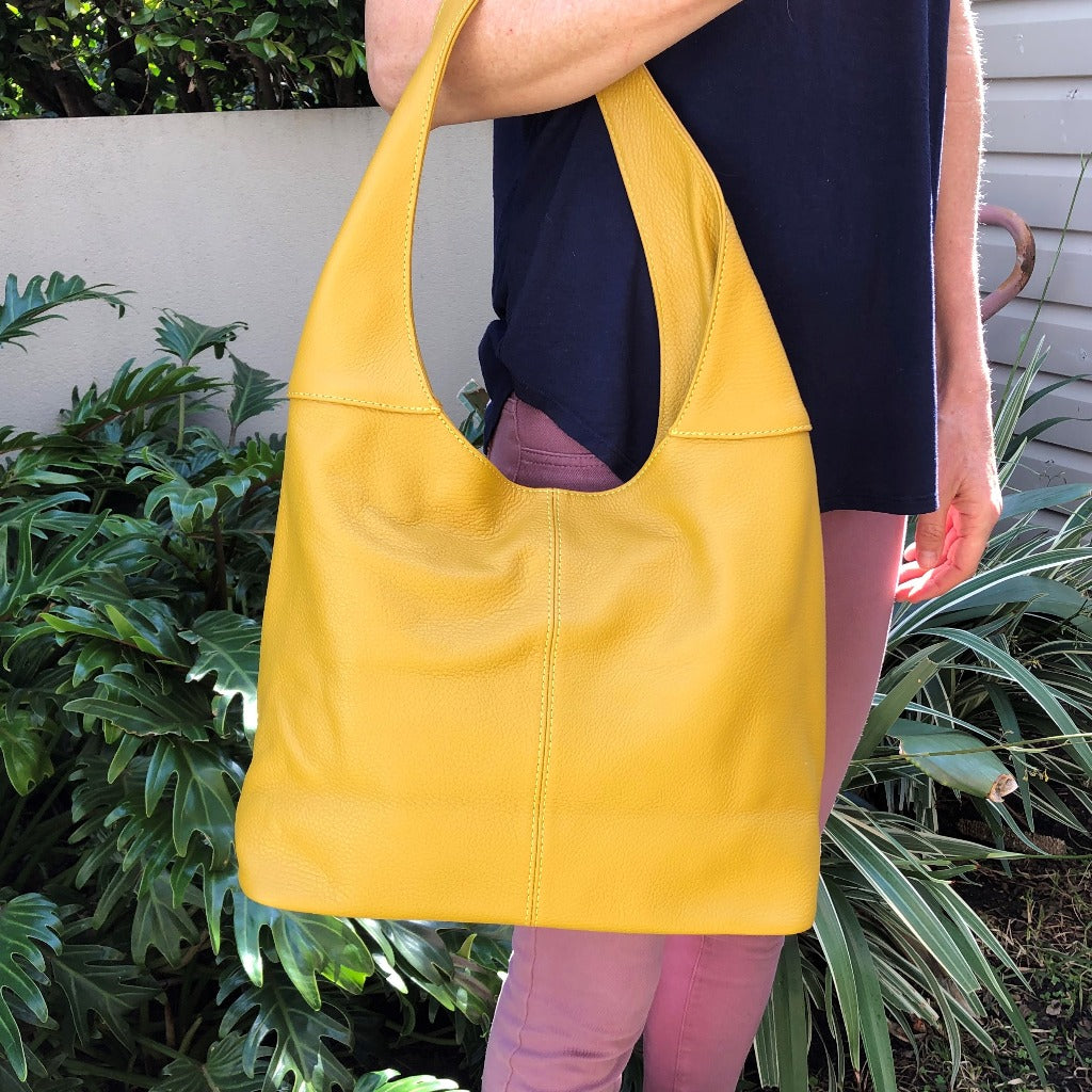 Woman holding the gold or mustard yellow Coco bag