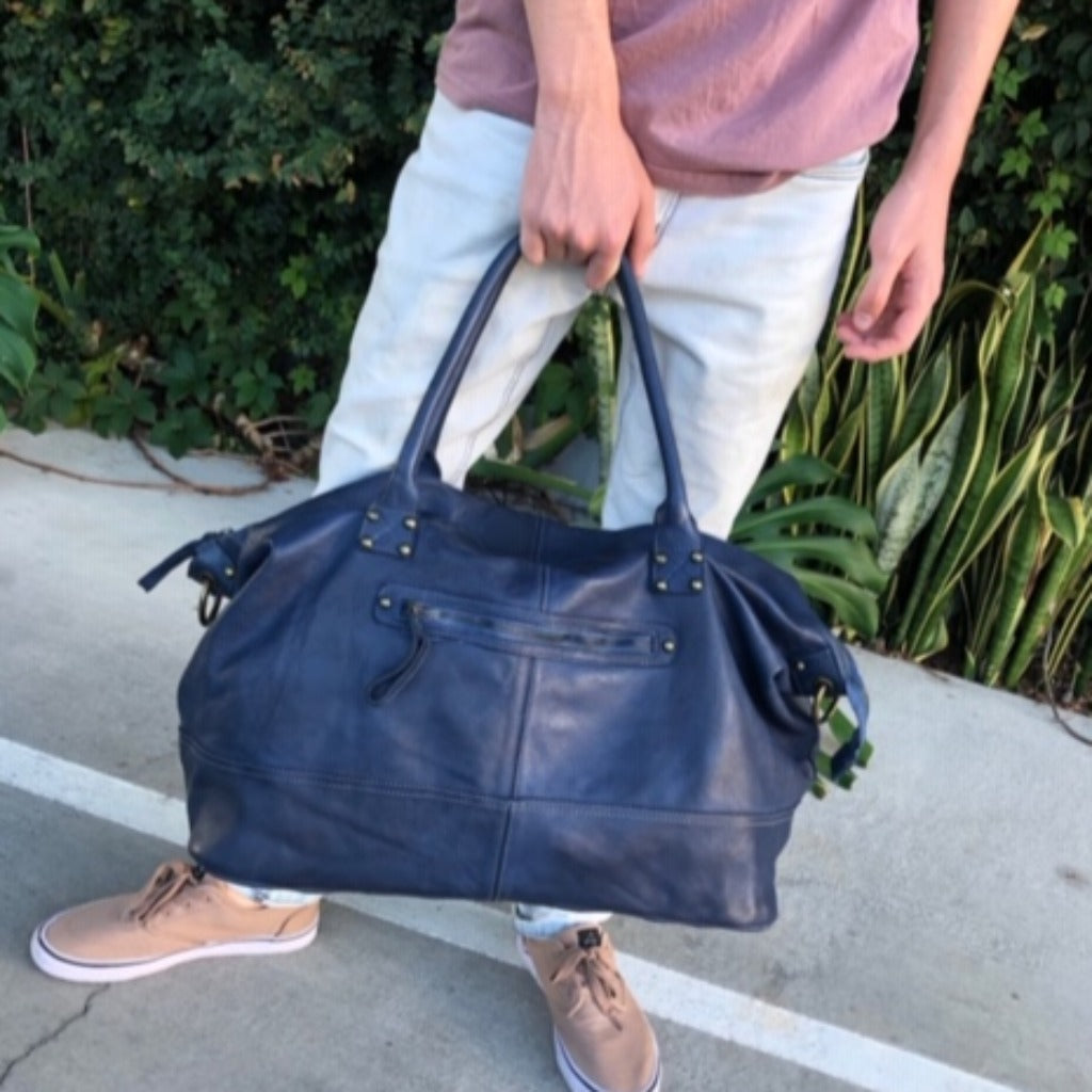 man holding blue weekend bag
