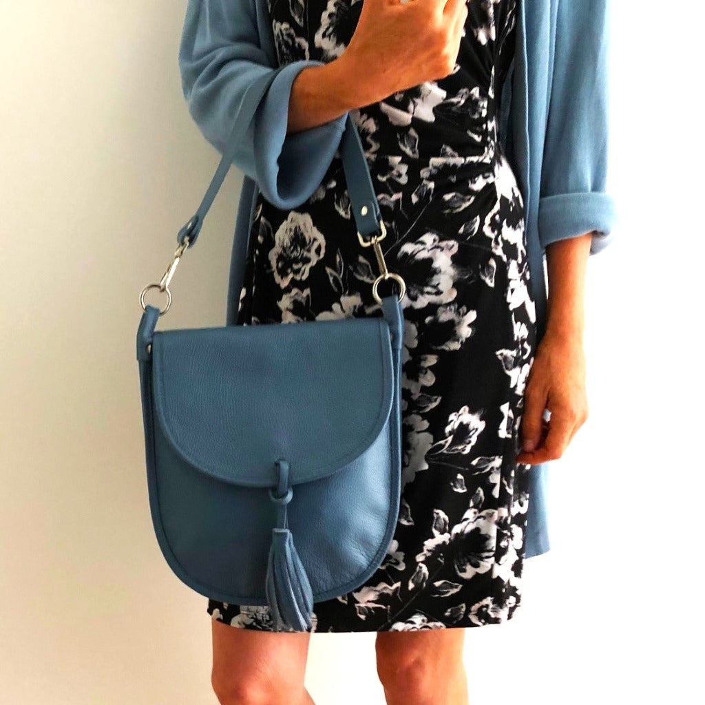 Woman holding the Oriel bag in denim blue