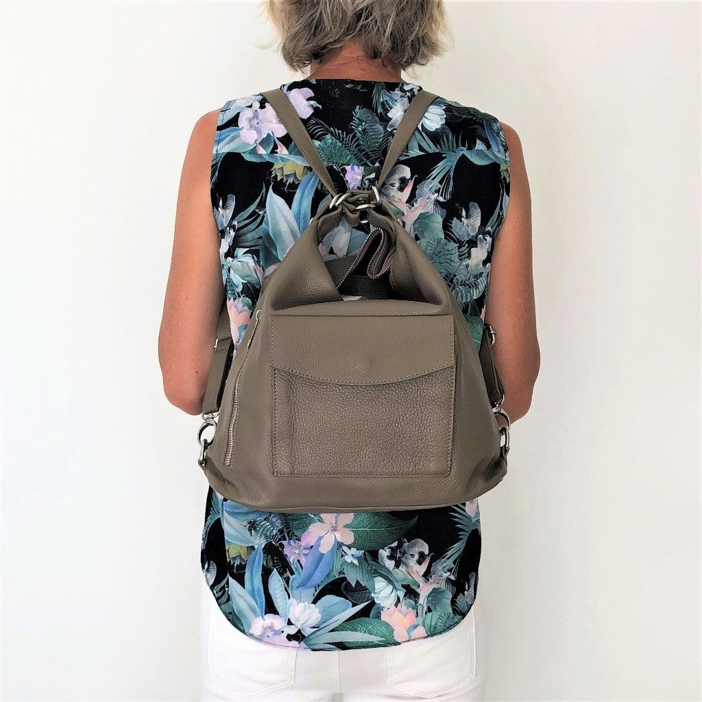Woman wearing the taupe Phillipa bag as a backpack