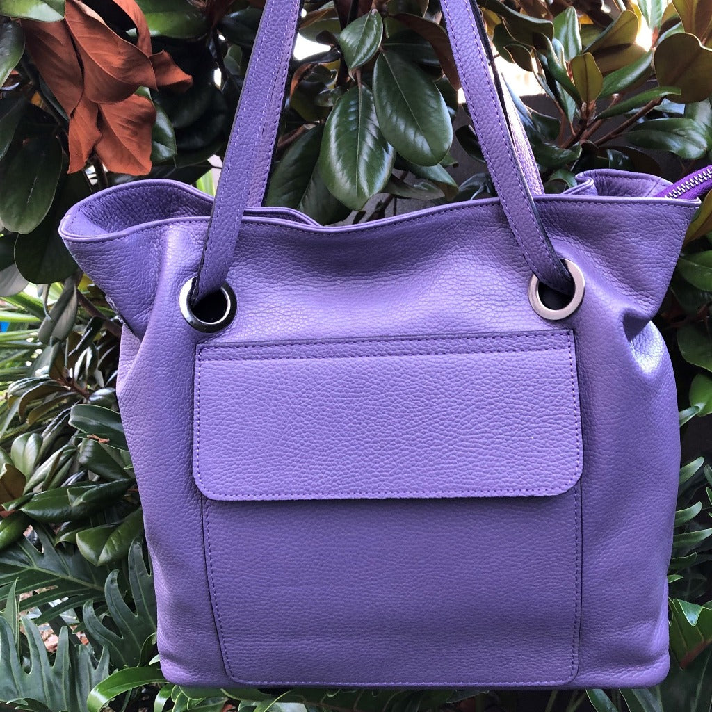 Photo of the Priscilla bag in light purple hanging in a tree