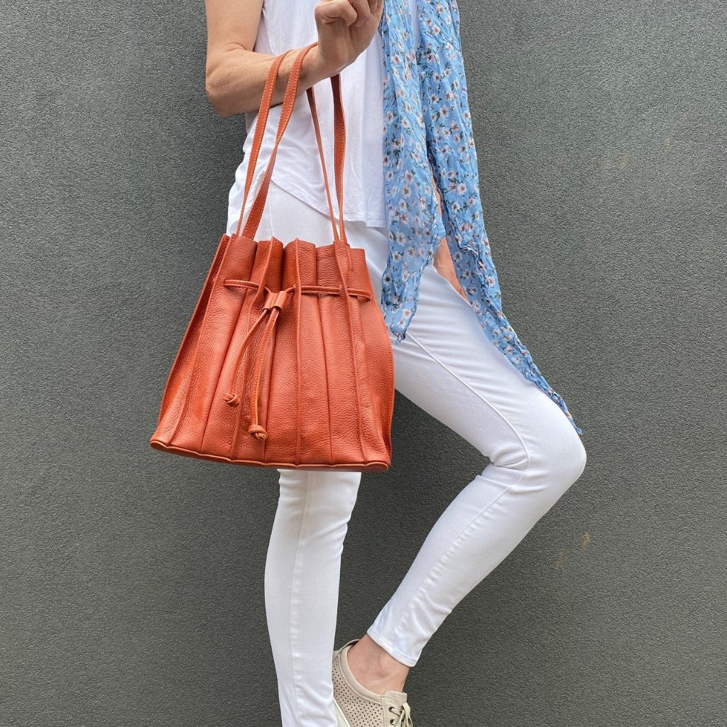 Swrella Handbags Woman holding the Susie bag in burnt orange