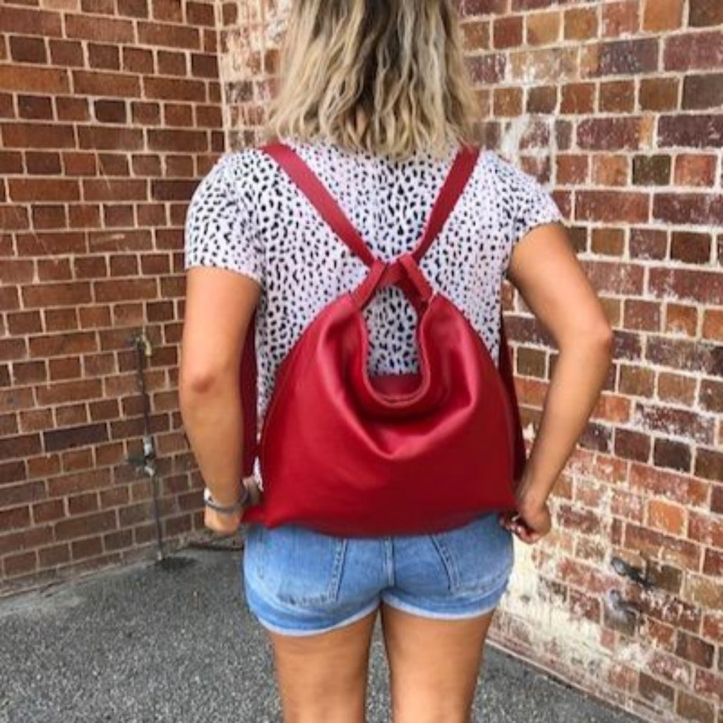 Woman wearing the red Adelaide bag as a backpack