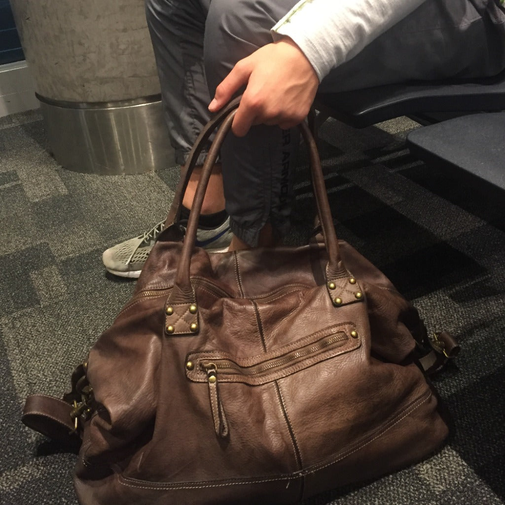 Man holding the Alfredo bag in dark brown