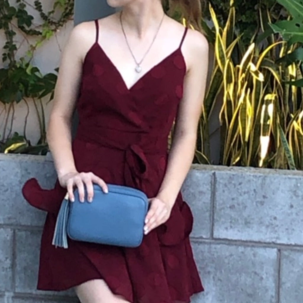 woman holding the Ella cross body bag in denim blue