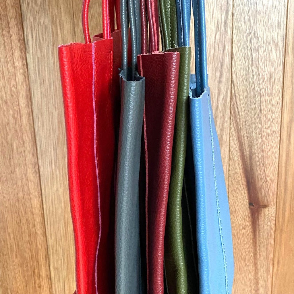 Muzi bags in (left to right) red, dark grey, burgundy, olive and denim blue