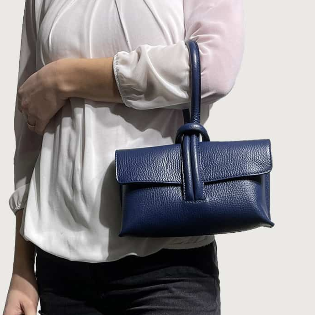 Woman holding the Rachelle clutch in navy