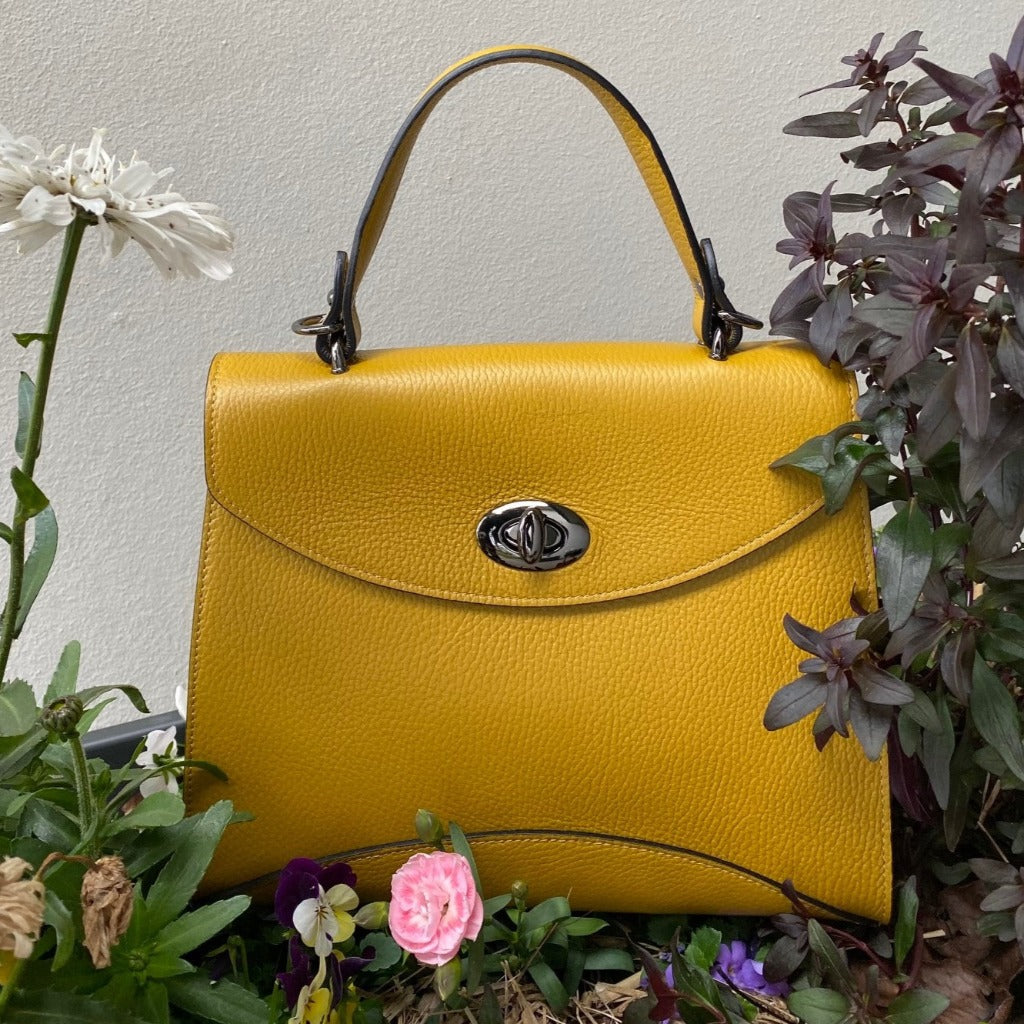 Rita bag in mustard yellow amongst flowers