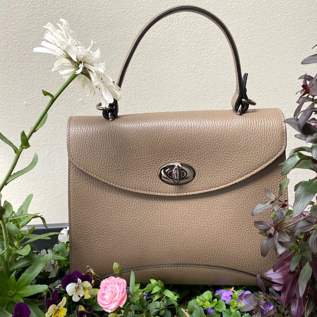 Rita bag in taupe in a flower bed